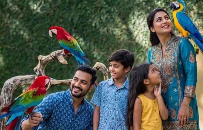 Family meeting colourful tropical birds and parrots at Bali Bird Park on a private family nature tour